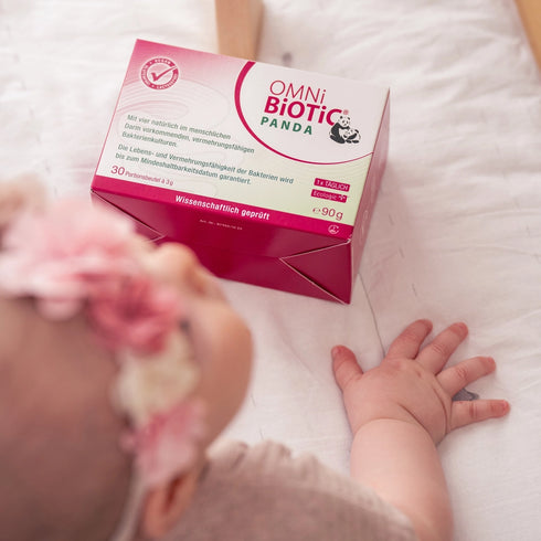 Ein Baby krabbelt zu einer Packung OMNi-BiOTiC PANDA
